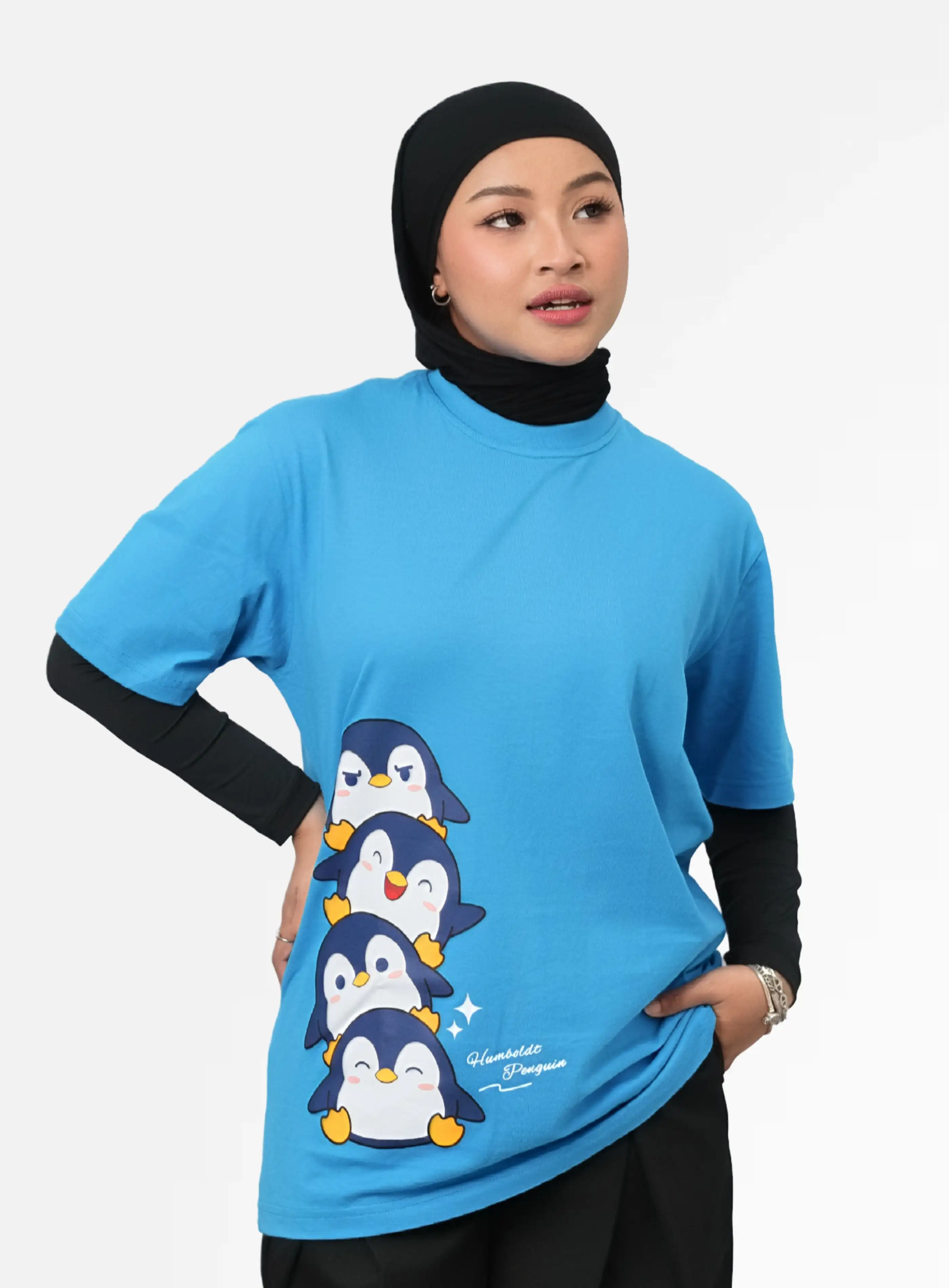 Kaos oversized warna turkis dengan sablon karakter penguin dan tulisan Humboldt Penguin