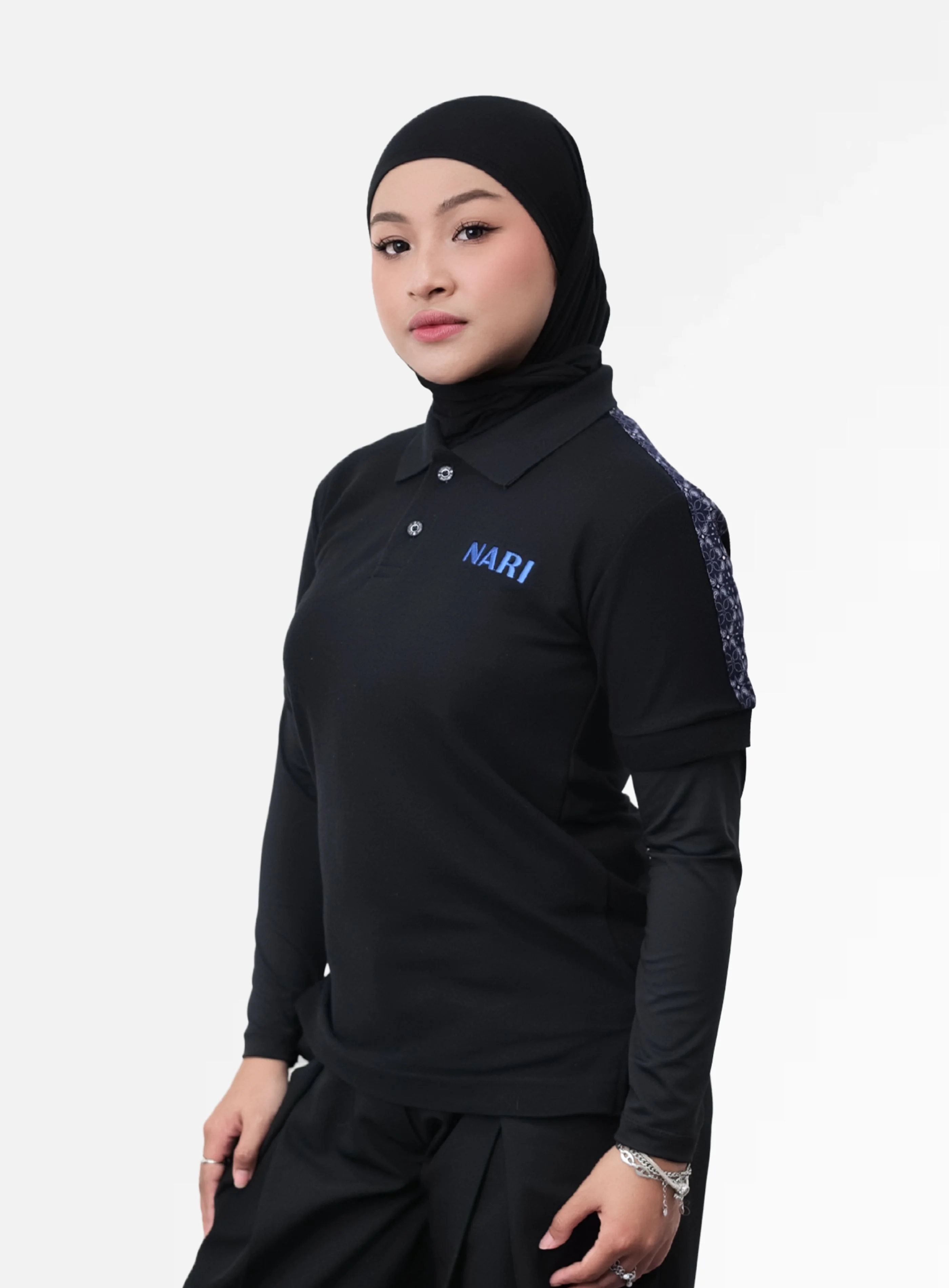 Polo shirt lengan panjang warna navy dengan kombinasi kain motif batik di bahu dan bordir logo Nari